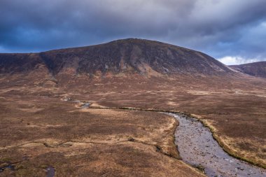 İskoçya 'da bir kış günü Glencoe' daki dağların, nehirlerin ve vadilerin insansız hava aracı görüntüsü.