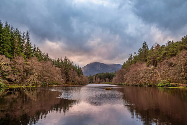 Beautiful landscape image of Glencoe Lochan with Pap of Glencoe in the distance on a Winter's evening