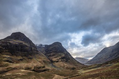 Islak bir kış gününde İskoçya 'nın Glencoe şehrindeki Üç Kız Kardeş' in destansı dramatik manzarası.