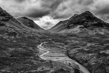 İskoçya 'da bir kış günü Glencoe, İskoçya' daki dağların, nehirlerin ve vadilerin dramatik siyah beyaz hava aracı görüntüsü.