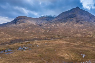 İskoçya 'da bir kış günü Glencoe' daki dağların, nehirlerin ve vadilerin insansız hava aracı görüntüsü.