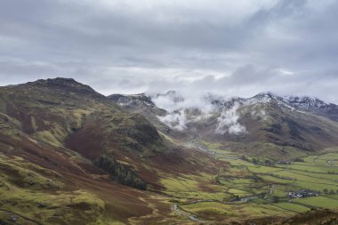 Langdale mızraklarının ve kışın alçak seviye bulutlar ve sisli vadisinin destansı uçan hava aracı görüntüsü.