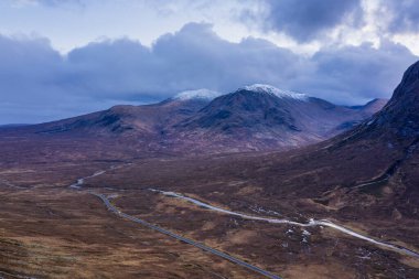 İskoçya 'da bir kış günü Glencoe' daki dağların, nehirlerin ve vadilerin insansız hava aracı görüntüsü.
