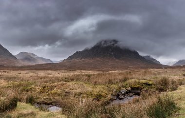 Buachaille Etive Mor ve River Etive 'in destansı dramatik manzarası İskoçya' da bir kış sabahı karamsar gökyüzü ve aydınlatma ile