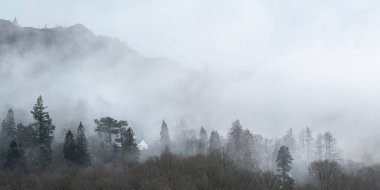 Elterwater 'dan Langdale Pikes dağlarına doğru sisli kış sabahında büyüleyici manzara.
