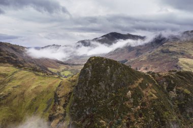 Langdale mızraklarının ve kışın alçak seviye bulutlar ve sisli vadisinin destansı uçan hava aracı görüntüsü.