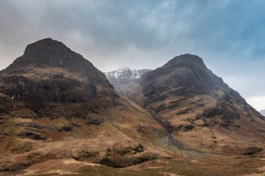 Islak bir kış gününde İskoçya 'nın Glencoe şehrindeki Üç Kız Kardeş' in destansı dramatik manzarası.