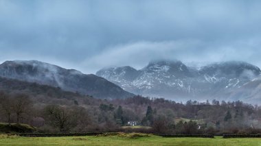 Elterwater 'dan Langdale Pikes dağlarına doğru sisli kış sabahında büyüleyici manzara.