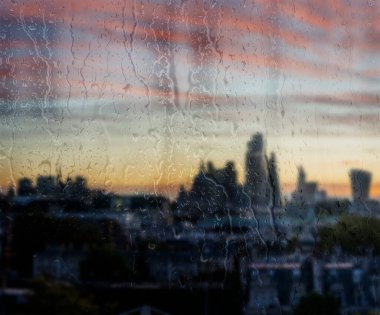 Camdan süzülen yağmur damlalarıyla Londra şehrinin kavramsal manzarası.