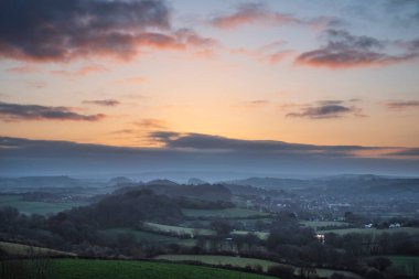 Dorset 'te bir bahar sabahı Symondsbury köyüne doğru sisli manzaranın çarpıcı güzel gündoğumu manzarası
