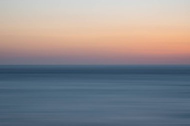 Sakin denizin ve renkli günbatımının güzel, uzun pozlama manzarası.