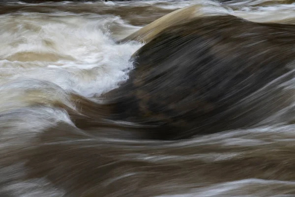 川の岩の上に速く流れる水の長い露出の詳細の美しい美術風景のイメージ — ストック写真