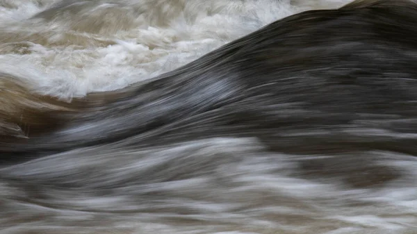 川の岩の上に速く流れる水の長い露出の詳細の美しい美術風景のイメージ — ストック写真