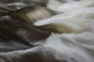 Nehirdeki kayaların üzerinden hızlı akan suyun uzun pozlama detaylarının güzel güzel sanat manzarası.