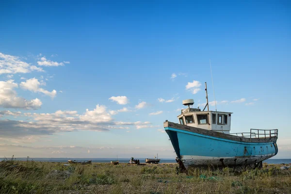 Barco de pesca abandonado na paisagem da praia ao pôr do sol — Fotografia de Stock