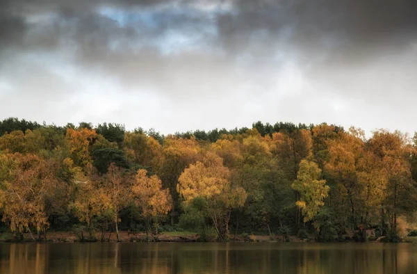 Hermosas vibrantes refleciones de bosque de otoño en aguas tranquilas del lago — Foto de Stock