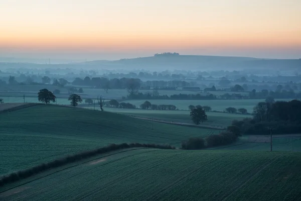 Prachtige zonsopgang boven mist lagen in platteland landschap — Stockfoto