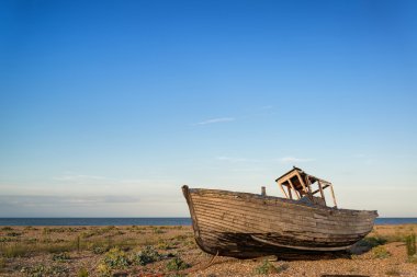 Gün batımında plaj manzara üzerinde terk edilmiş balıkçı teknesi