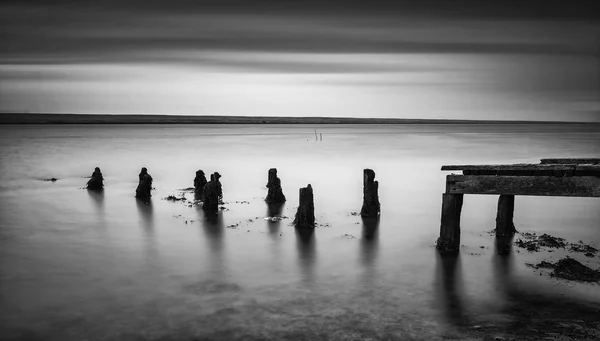 Long exposure landscape of old derelict jetty extending into lak — Stock Photo, Image