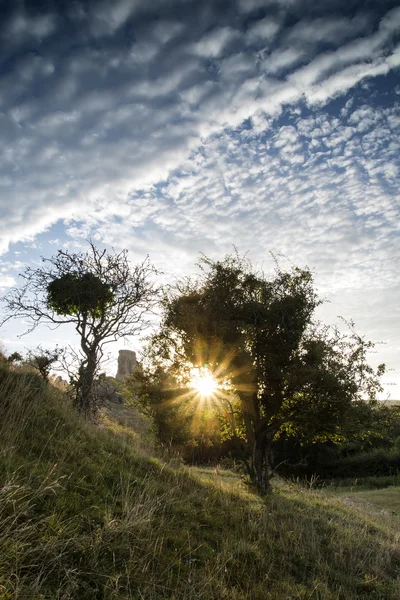 Kasteel ruïnes landschap bij zonsopgang met inspirerende sunburst worden — Stockfoto