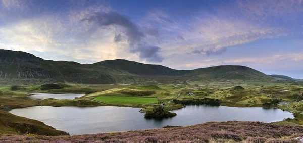 Stunning sunrise panorama landscape of heather with mountain lak — Stock Photo, Image