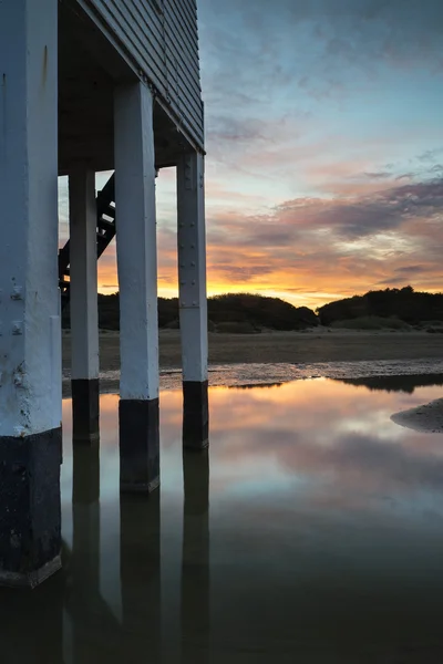 Gyönyörű táj sunrise gólyaláb világítótoronyig strand — Stock Fotó