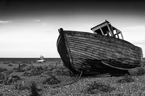 Barco de pesca abandonado na paisagem da praia ao pôr do sol preto e wh — Fotografia de Stock