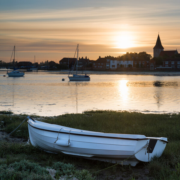 Beautiful Summer sunset landscape over low tide harbor with moor