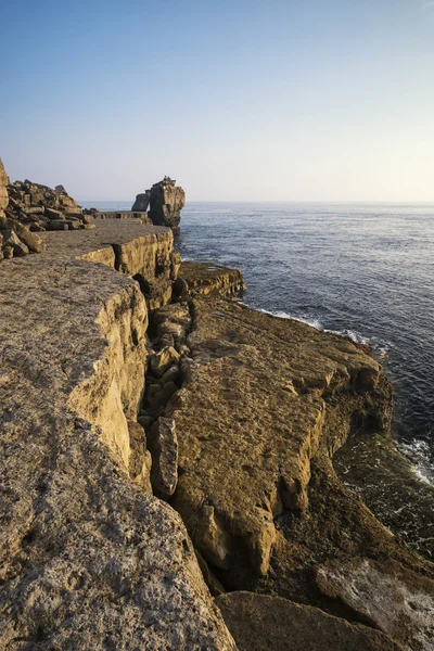 Krásný skalnatý útes krajina s západ slunce nad oceánem — Stock fotografie