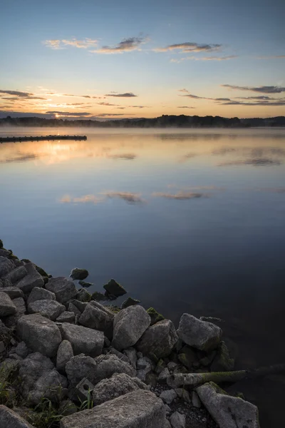 Východ slunce pulzující krajina z mola na klidné jezero — Stock fotografie