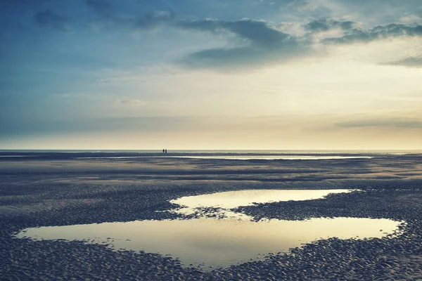 Imagem de paisagem conceitual de duas pessoas na praia remota com — Fotografia de Stock