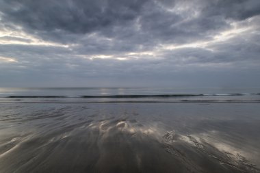 Islak plaj manzara üzerinde yansıyan moody ramatic gökyüzü