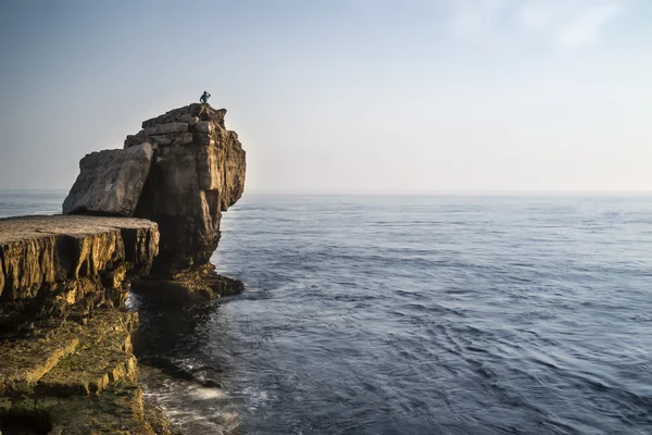 Bela paisagem rochosa penhasco com pôr do sol sobre o oceano com undi — Fotografia de Stock