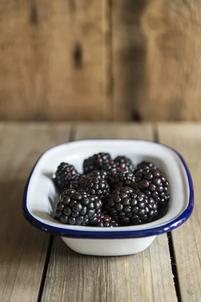 Blackberries in rustic kitchen setting with wooden background — Stock Photo, Image