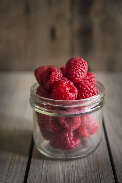 Raspberries in rustic kitchen setting with wooden background — Stock Photo, Image