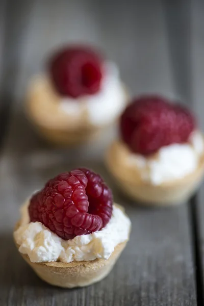 Raspberry tartlets on rustic wooden kitchen  background — Stock Photo, Image