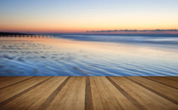 Bella spiaggia bassa marea alba vibrante con tavole di legno floo — Foto Stock