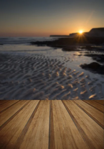 Lunga esposizione paesaggio roccioso litorale al tramonto con pl di legno — Foto Stock