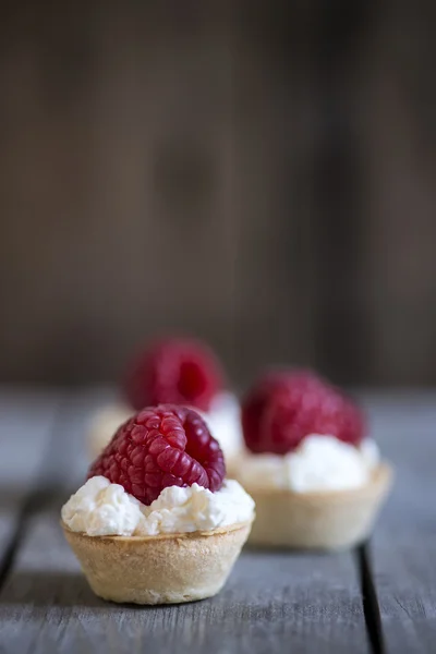 Raspberry tartlets on rustic wooden kitchen  background — Stock Photo, Image