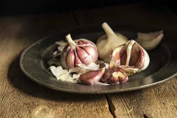 Fresh garlic cloves in moody natural lighting set up with vintag — Stock Photo, Image