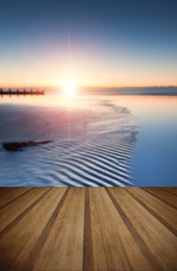 Güzel düşük tide beach canlı gündoğumu ile ahşap plakalar floo