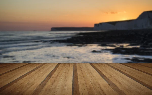 Paisaje de larga exposición costa rocosa al atardecer con pl de madera —  Fotos de Stock