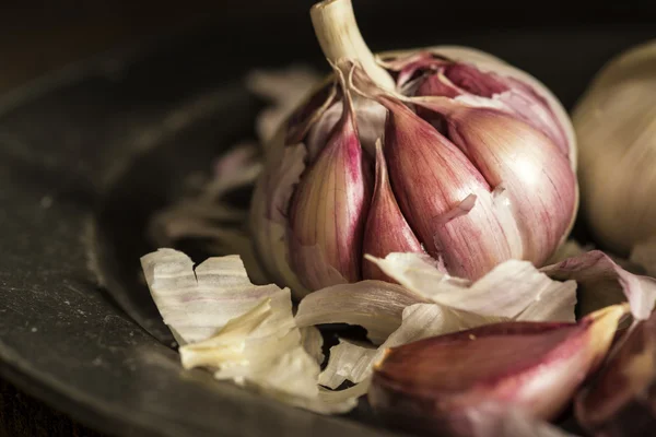 Fresh garlic cloves in moody natural lighting set up with vintag — Stock Photo, Image