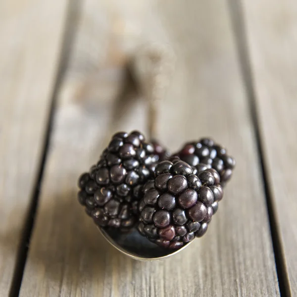 Blackberries in rustic kitchen setting with wooden background — Stock Photo, Image