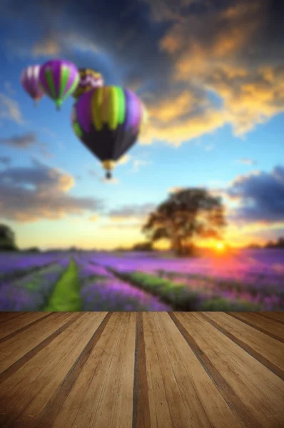 Hete lucht ballonnen vliegen over lavendel landschap zonsondergang met hout — Stockfoto