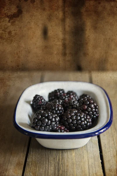 Blackberries in rustic kitchen setting with wooden background wi — Stock Photo, Image