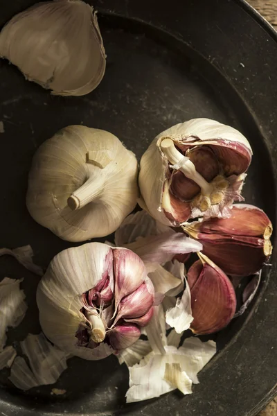Fresh garlic cloves in moody natural lighting set up with vintag — Stock Photo, Image