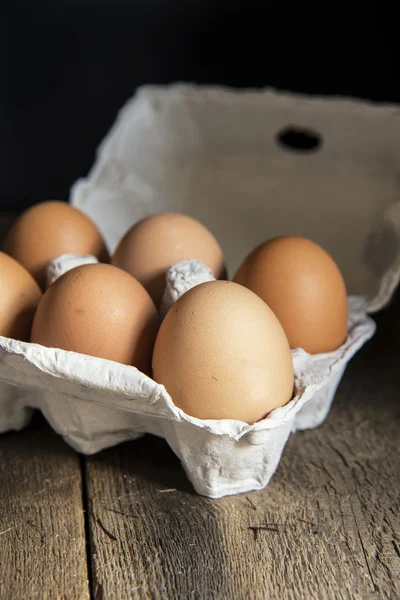 Huevos frescos en caja de huevos en luz natural de mal humor vintage retro st — Foto de Stock