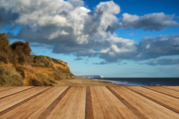 Paesaggio vivace tramonto sulla spiaggia e scogliere con tavole di legno f — Foto Stock