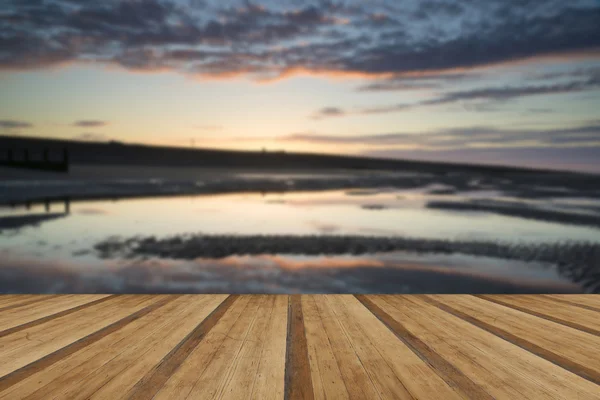 Vibrant sunrise landscape reflected in low tide water on beach w